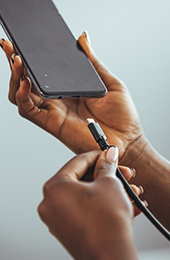 Hands plugging a charger into a smart phone