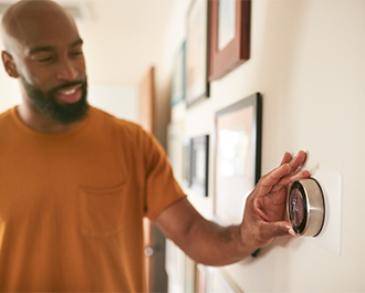 Person adjusting thermostat 