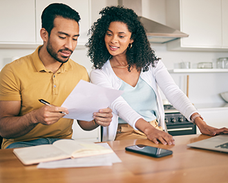 Family in kitchen reviewing a document 