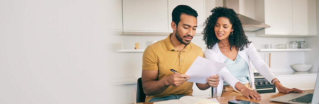 Family in kitchen reviewing a document 