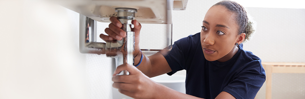 Woman fixing plumbing 