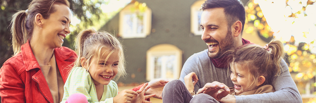 Happy family in front of house