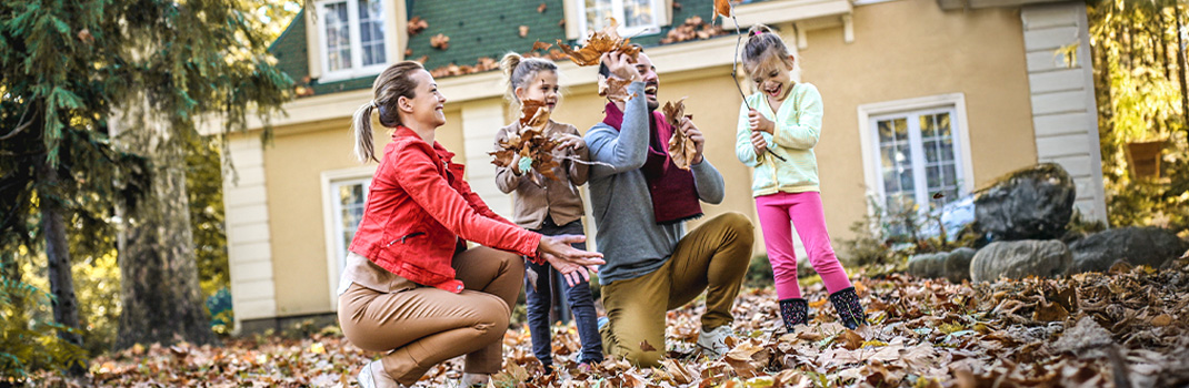 Happy family in front of house