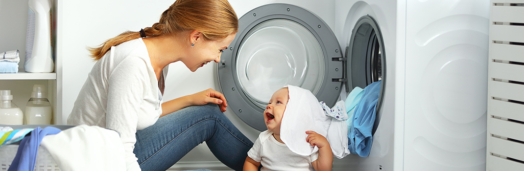 Lady with baby next to washing machine