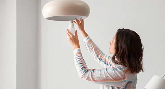 Woman replacing a lightbulb