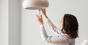 Woman replacing a lightbulb